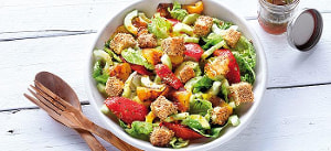 Grüner Salat mit gebackenem Schafskäse und Paprika in Tomatendressing