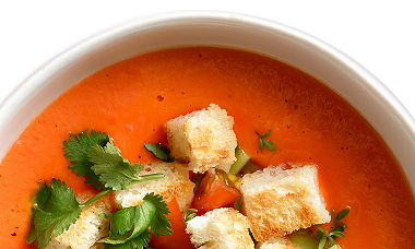 Eine Schüssel Tomatensuppe mit Croutons und Kräutern