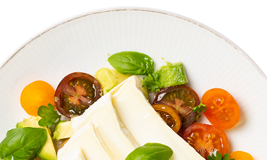 Mozzarella auf Bunten Tomaten mit Basilkumblättern dekoriert